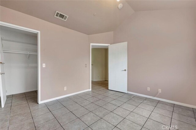 13421 Hubbard St Unit 125, Sylmar, CA 91342 - unfurnished bedroom featuring lofted ceiling, light tile patterned floors, a closet, baseboards, and a walk in closet