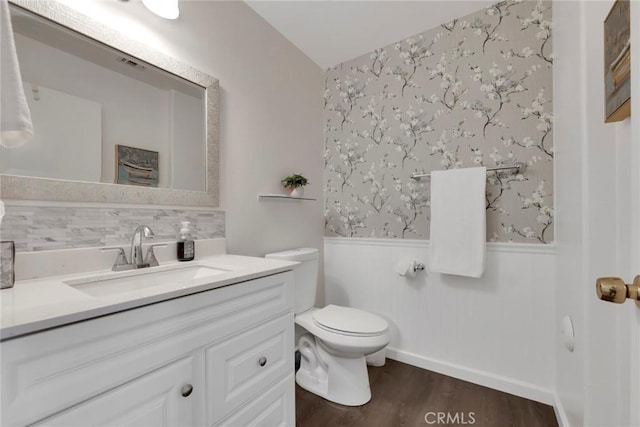 13421 Hubbard St Unit 125, Sylmar, CA 91342 - bathroom featuring wainscoting, vanity, wood finished floors, toilet, and wallpapered walls