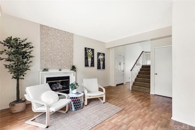 13421 Hubbard St Unit 125, Sylmar, CA 91342 - sitting room featuring light wood-style floors, stairway, and a large fireplace
