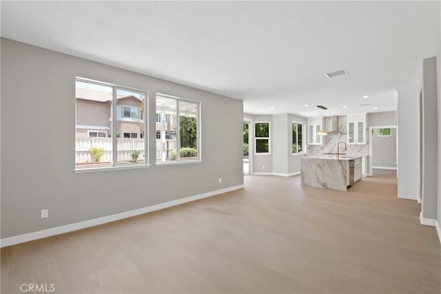 9406 Glenaire Ct, Rancho Cucamonga, CA 91730 - unfurnished living room featuring light wood-style floors, a sink, baseboards, and recessed lighting