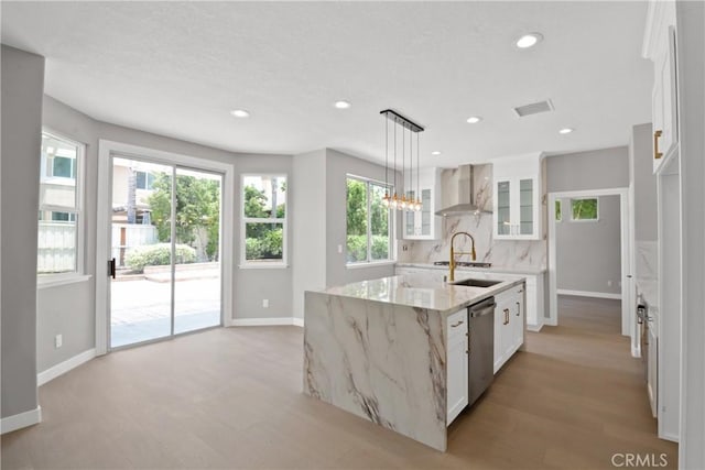 9406 Glenaire Ct, Rancho Cucamonga, CA 91730 - kitchen featuring wall chimney range hood, decorative backsplash, glass insert cabinets, stainless steel dishwasher, and light wood-style floors