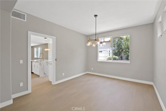 9406 Glenaire Ct, Rancho Cucamonga, CA 91730 - empty room with a chandelier, light wood-style flooring, a sink, and baseboards