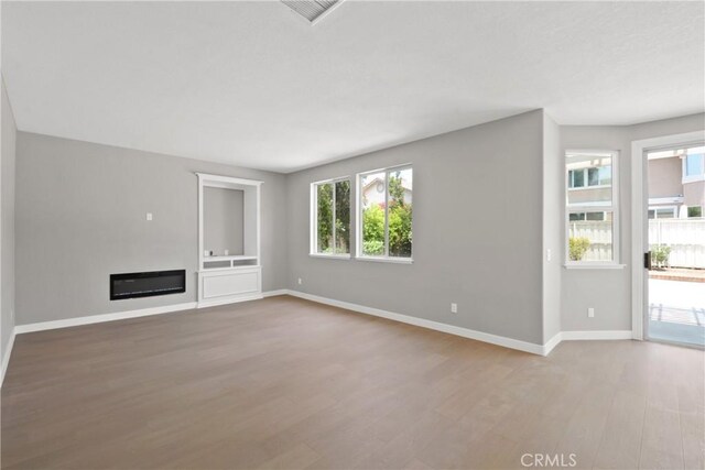 9406 Glenaire Ct, Rancho Cucamonga, CA 91730 - unfurnished living room with wood finished floors, baseboards, and a glass covered fireplace