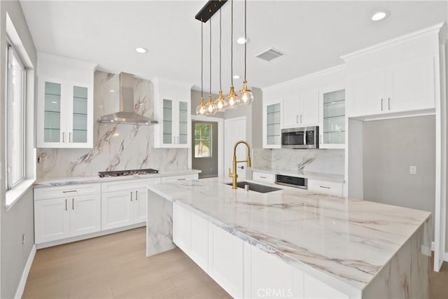 9406 Glenaire Ct, Rancho Cucamonga, CA 91730 - kitchen featuring wall chimney exhaust hood, a sink, stainless steel microwave, a spacious island, and ornamental molding