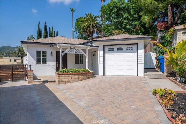 2035 Las Colinas Ave, Los Angeles, CA 90041 - single story home featuring stucco siding, a gate, an attached garage, and decorative driveway