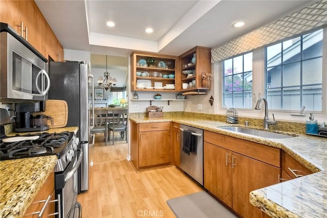 543 Rockport Ct, Encinitas, CA 92024 - kitchen with appliances with stainless steel finishes, brown cabinetry, a sink, light wood-style floors, and light stone counters