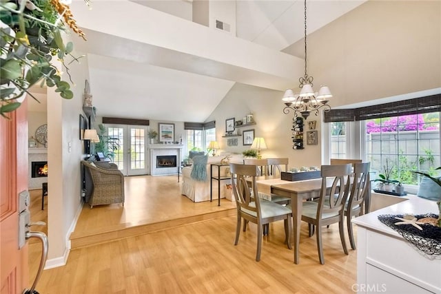 543 Rockport Ct, Encinitas, CA 92024 - dining area featuring a lit fireplace, high vaulted ceiling, light wood finished floors, a chandelier, and baseboards
