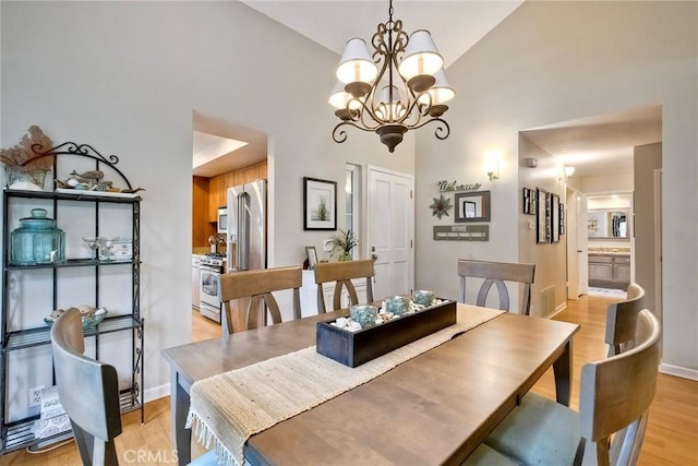 543 Rockport Ct, Encinitas, CA 92024 - dining area with light wood-type flooring, high vaulted ceiling, a chandelier, and baseboards
