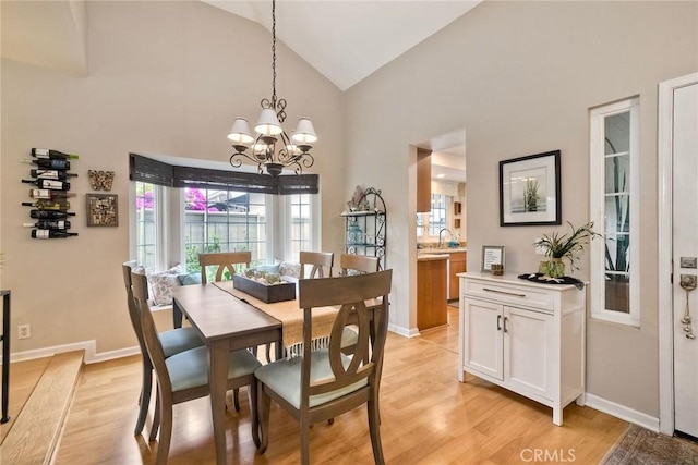 543 Rockport Ct, Encinitas, CA 92024 - dining area with light wood-style floors, a chandelier, high vaulted ceiling, and baseboards