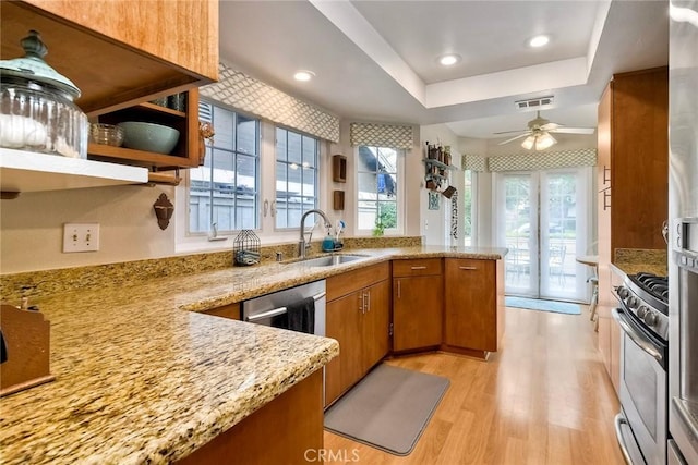 543 Rockport Ct, Encinitas, CA 92024 - kitchen with a sink, stainless steel gas range oven, brown cabinetry, light wood-style floors, and a peninsula