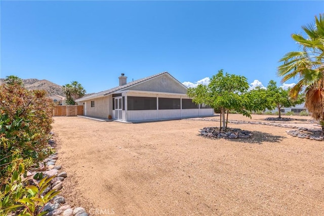 57146 Selecta Ave, Yucca Valley, CA 92284 - rear view of house with a sunroom and a chimney
