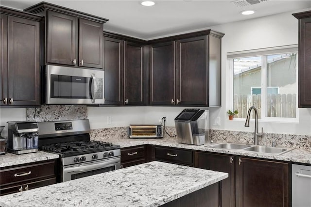 10028 Fire Is, Bakersfield, CA 93313 - kitchen with stainless steel appliances, a sink, dark brown cabinetry, and recessed lighting