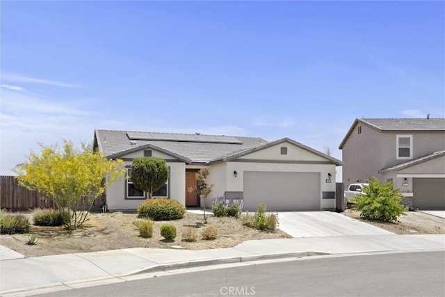 10028 Fire Is, Bakersfield, CA 93313 - view of front facade with a garage, solar panels, driveway, a tiled roof, and stucco siding