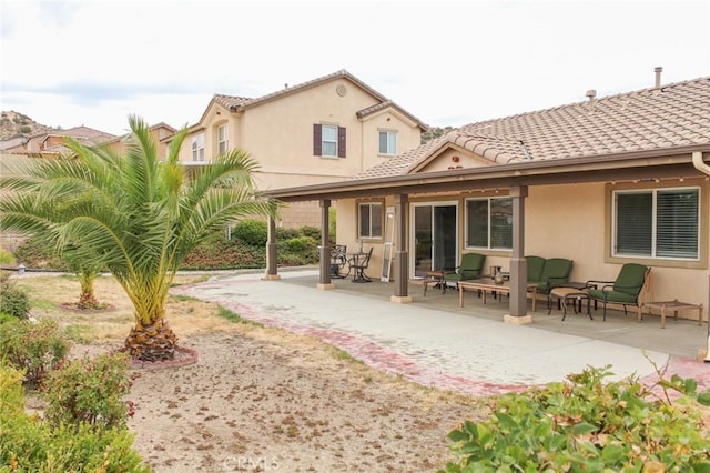 38564 Pallas Ct, Palmdale, CA 93551 - back of house featuring a patio, stucco siding, outdoor lounge area, and a tiled roof