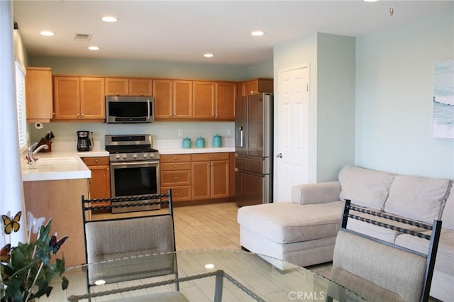 38564 Pallas Ct, Palmdale, CA 93551 - kitchen featuring appliances with stainless steel finishes, a sink, light countertops, light wood-type flooring, and recessed lighting