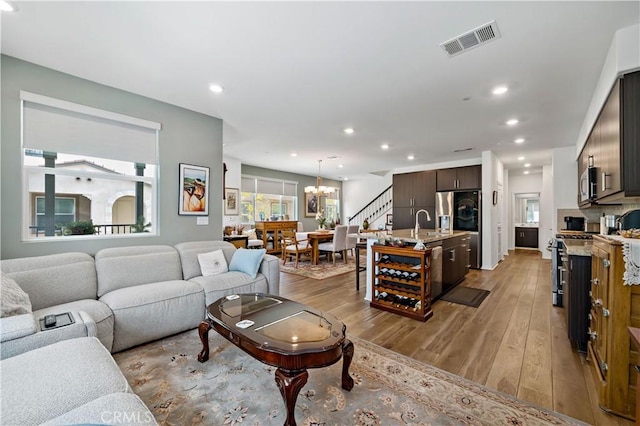 15210 Horizon St Unit 2, Fontana, CA 92336 - living room with a chandelier, light wood-style flooring, stairway, and recessed lighting