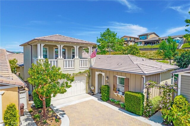 112 Cerrero Ct, Rancho Mission Viejo, CA 92694 - view of front facade featuring a tile roof, decorative driveway, an attached garage, board and batten siding, and a residential view