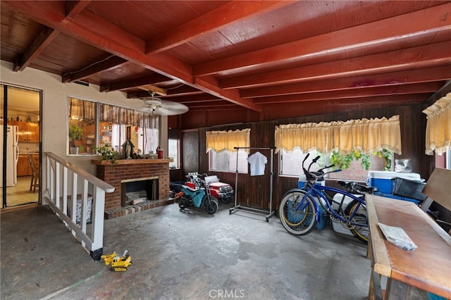 6532 Bonnie Vale Ave, Pico Rivera, CA 90660 - garage featuring freestanding refrigerator, wood walls, a ceiling fan, and a brick fireplace