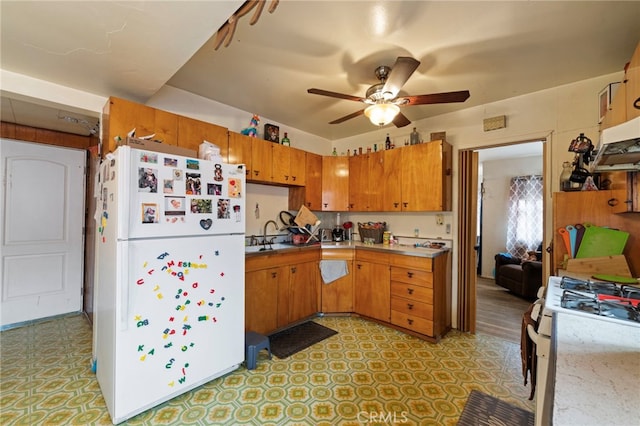 6532 Bonnie Vale Ave, Pico Rivera, CA 90660 - kitchen with white appliances, brown cabinetry, ceiling fan, light countertops, and light flooring