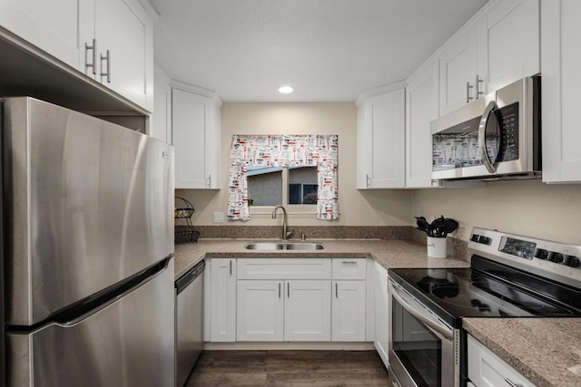 3673 Brandywine St, Oceanside, CA 92057 - kitchen with stainless steel appliances, white cabinetry, dark wood finished floors, recessed lighting, and light countertops
