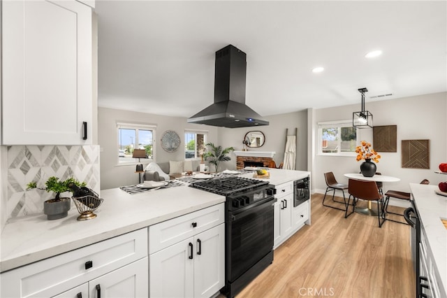 1905 Davis St, Corona, CA 92882 - kitchen with island exhaust hood, gas stove, light wood-style floors, light countertops, and recessed lighting