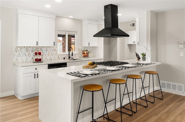 1905 Davis St, Corona, CA 92882 - kitchen featuring island range hood, a sink, a kitchen breakfast bar, light wood-style floors, and recessed lighting