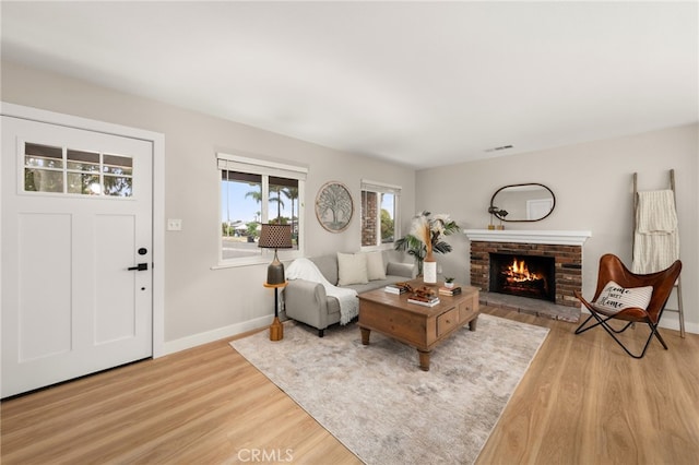 1905 Davis St, Corona, CA 92882 - living room featuring light wood finished floors, baseboards, and a brick fireplace