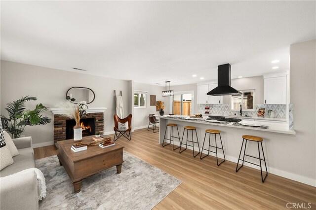 1905 Davis St, Corona, CA 92882 - living room featuring light wood-type flooring, a brick fireplace, recessed lighting, and baseboards