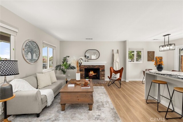 1905 Davis St, Corona, CA 92882 - living room featuring light wood-style flooring, healthy amount of natural light, a fireplace, and baseboards