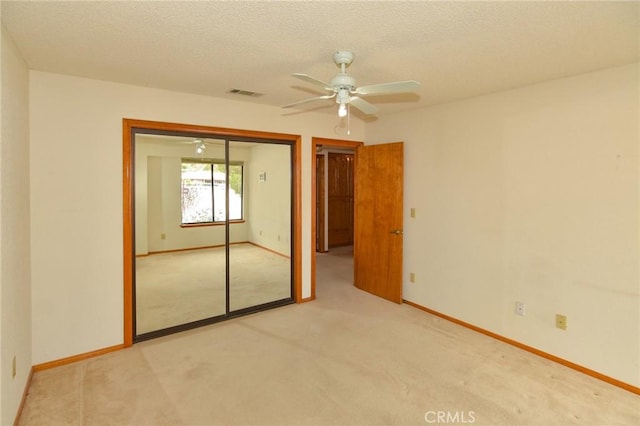22478 Poppy Rd, Apple Valley, CA 92308 - unfurnished bedroom with light carpet, a closet, baseboards, a textured ceiling, and a ceiling fan