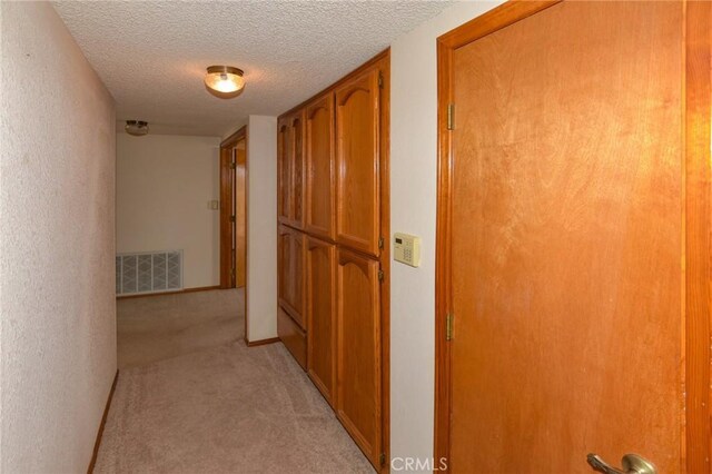 22478 Poppy Rd, Apple Valley, CA 92308 - hall with light carpet, a textured ceiling, and baseboards
