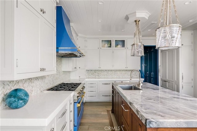 505 W Edgewater Ave, Newport Beach, CA 92661 - kitchen with wall chimney range hood, stainless steel stove, a sink, a center island with sink, and dark wood finished floors