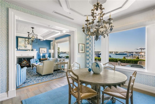 505 W Edgewater Ave, Newport Beach, CA 92661 - dining room with wallpapered walls, a chandelier, wood finished floors, a lit fireplace, and beam ceiling