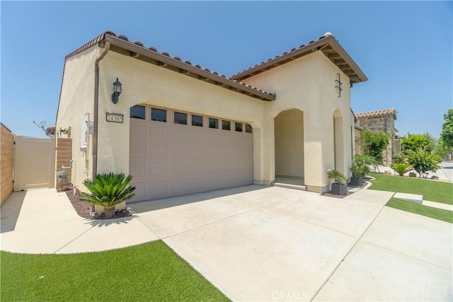 24385 Overlook Dr, Corona, CA 92883 - mediterranean / spanish home with stucco siding, a garage, driveway, a tiled roof, and a gate