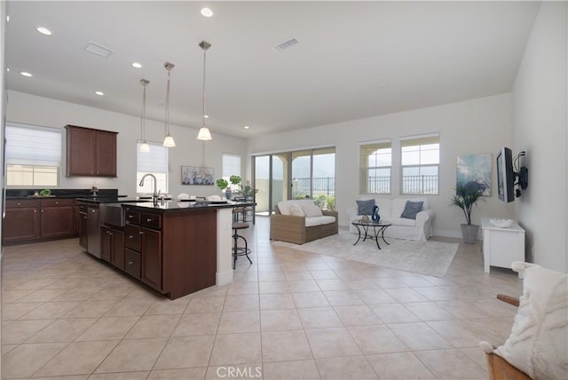 24385 Overlook Dr, Corona, CA 92883 - kitchen featuring open floor plan, dark countertops, a kitchen breakfast bar, light tile patterned floors, and an island with sink