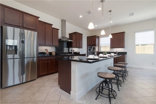 24385 Overlook Dr, Corona, CA 92883 - kitchen with stainless steel appliances, wall chimney range hood, dark countertops, an island with sink, and light tile patterned flooring
