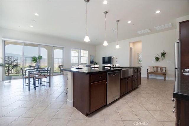 24385 Overlook Dr, Corona, CA 92883 - kitchen with dishwasher, dark countertops, light tile patterned floors, decorative light fixtures, and an island with sink