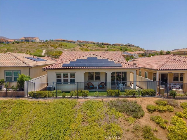 24385 Overlook Dr, Corona, CA 92883 - back of house with stucco siding, roof mounted solar panels, a fenced backyard, a tile roof, and a residential view