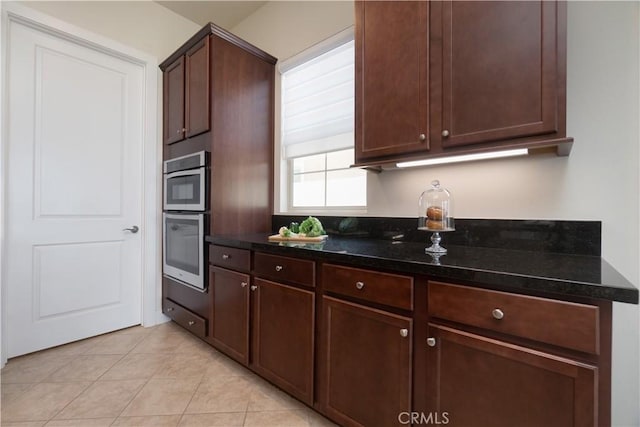 24385 Overlook Dr, Corona, CA 92883 - kitchen featuring dark stone counters, light tile patterned flooring, double oven, and dark brown cabinets