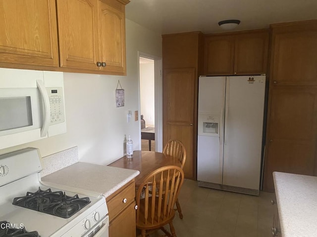 312 Rhodes Ct, Fillmore, CA 93015 - kitchen featuring white appliances, light countertops, brown cabinetry, and light tile patterned floors