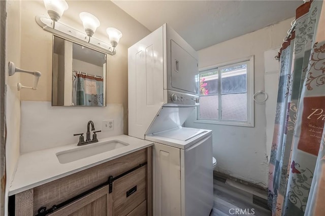 14410 Walnut Ave, Clearlake, CA 95422 - laundry room featuring estacked washer and dryer and wood finished floors