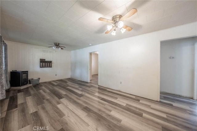 14410 Walnut Ave, Clearlake, CA 95422 - unfurnished living room with a ceiling fan, a wood stove, and wood finished floors