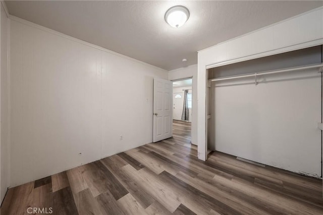 14410 Walnut Ave, Clearlake, CA 95422 - unfurnished bedroom featuring wood finished floors, a closet, and crown molding