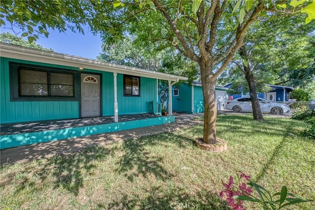 14410 Walnut Ave, Clearlake, CA 95422 - ranch-style home featuring covered porch, a front lawn, and board and batten siding