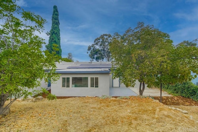 1125 Evilo St, El Cajon, CA 92021 - rear view of house featuring stucco siding and solar panels