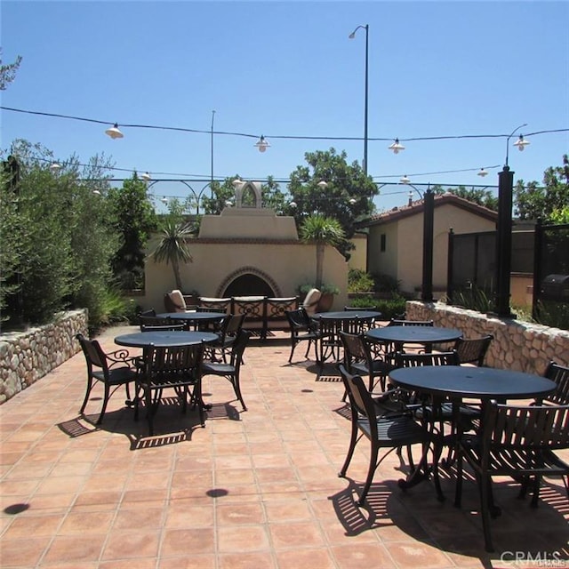 908 Grove Ct, Claremont, CA 91711 - view of patio with outdoor dining area and an outdoor fireplace