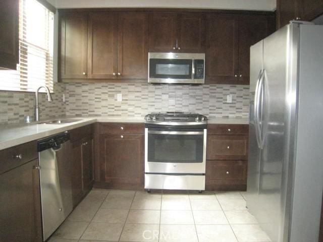908 Grove Ct, Claremont, CA 91711 - kitchen with stainless steel appliances, a sink, light countertops, decorative backsplash, and light tile patterned floors
