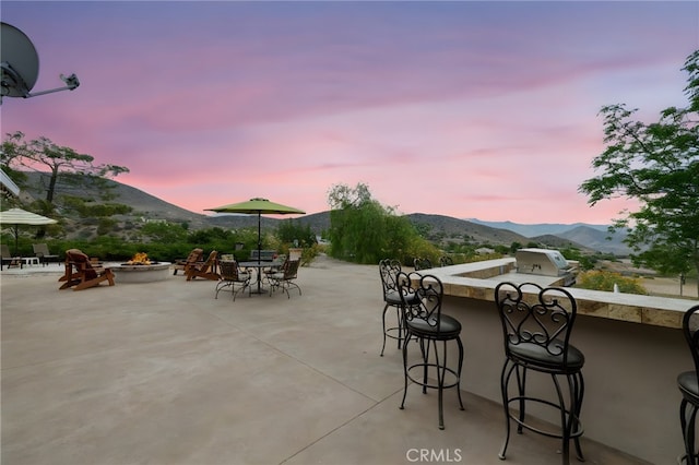 35122 Red Rover Mine Rd, Acton, CA 93510 - patio terrace at dusk with an outdoor fire pit, a mountain view, grilling area, and a patio