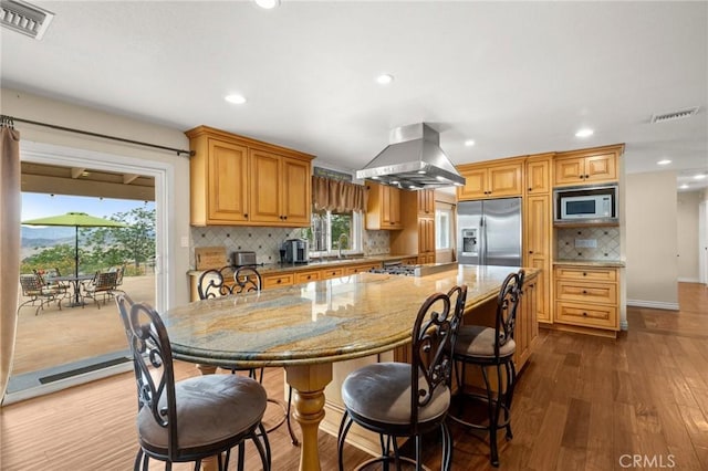 35122 Red Rover Mine Rd, Acton, CA 93510 - kitchen with stainless steel fridge, built in microwave, island exhaust hood, recessed lighting, and light stone counters