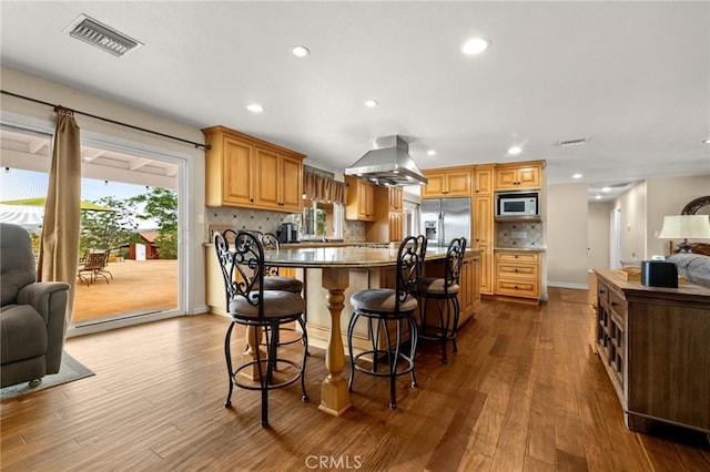35122 Red Rover Mine Rd, Acton, CA 93510 - kitchen with built in microwave, island exhaust hood, stainless steel fridge with ice dispenser, open floor plan, and dark wood finished floors